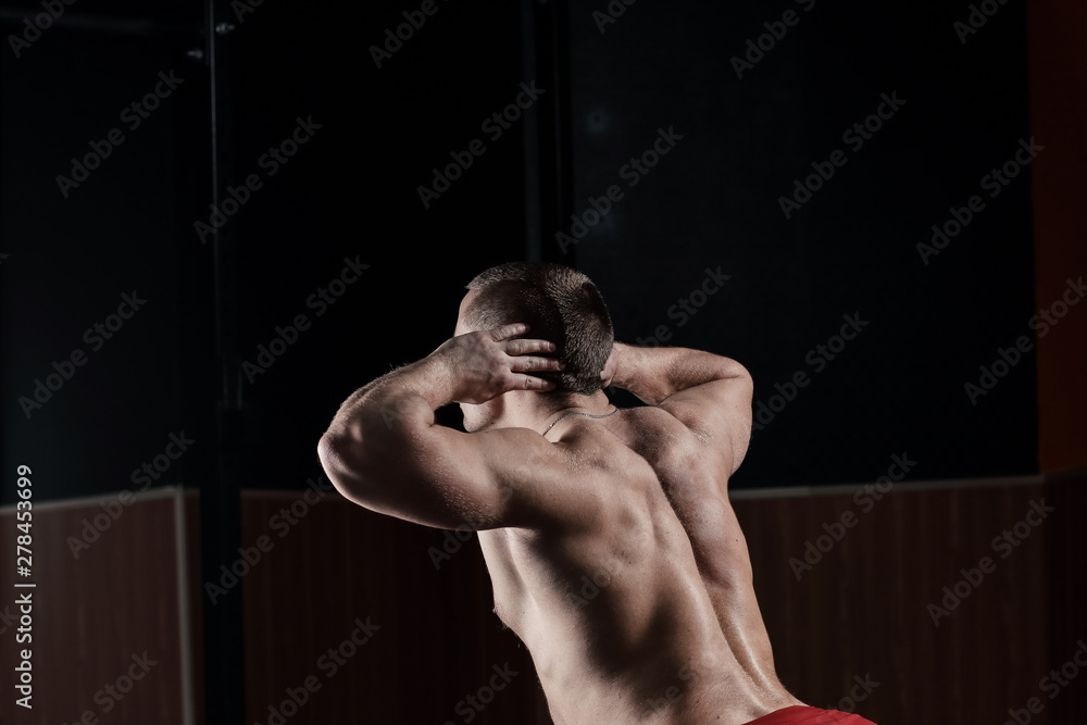 close up.rear view .a male bodybuilder performs an exercise - obrazy, fototapety, plakaty 