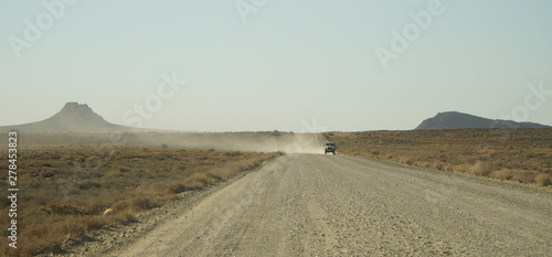 Photography Car driving on a road to the AfrikaBurn Festival in the Karoo desert of Tankwa Karoo National Park in South Africa