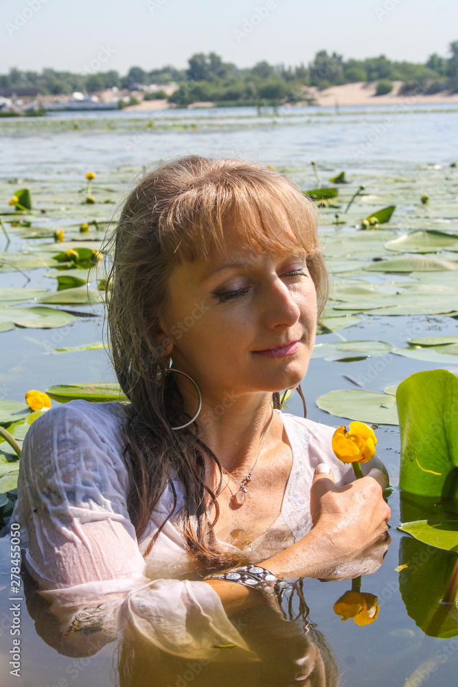 Tender close portrait of attractive young happy woman holding a lilie flower. Tender close portrait of attractive young happy woman holding a lilie flower.