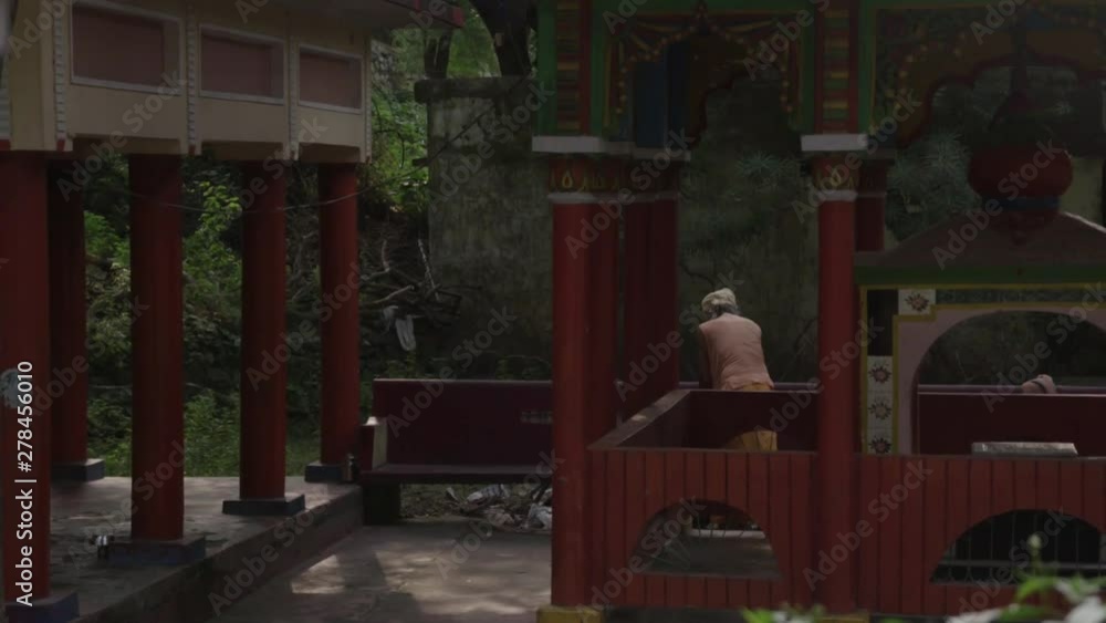 woman prays at temple in courtyard as camera moves in slow motion woman prays at temple in courtyard as camera moves in slow motion