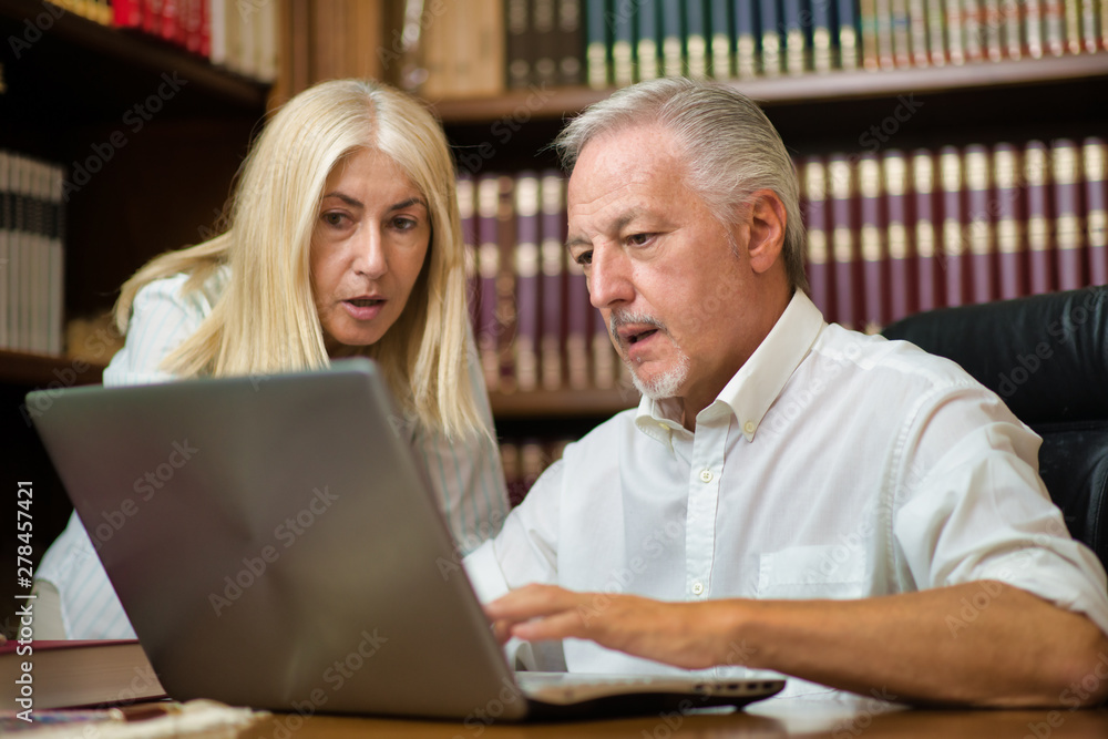People using a laptop computer in their office People using a laptop computer in their office