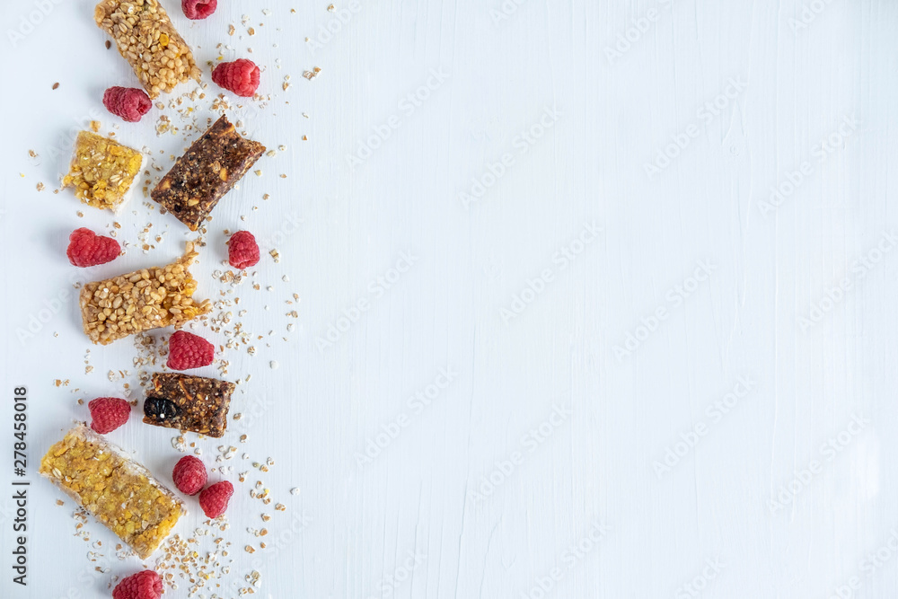 Granola for weight loss with raspberry berries. Background for text with fitness bars and raspberries jagolis on a white wooden background. Healthy snack Granola for weight loss with raspberry berries. Background for text with fitness bars and raspberries jagolis on a white wooden background. Healthy snack