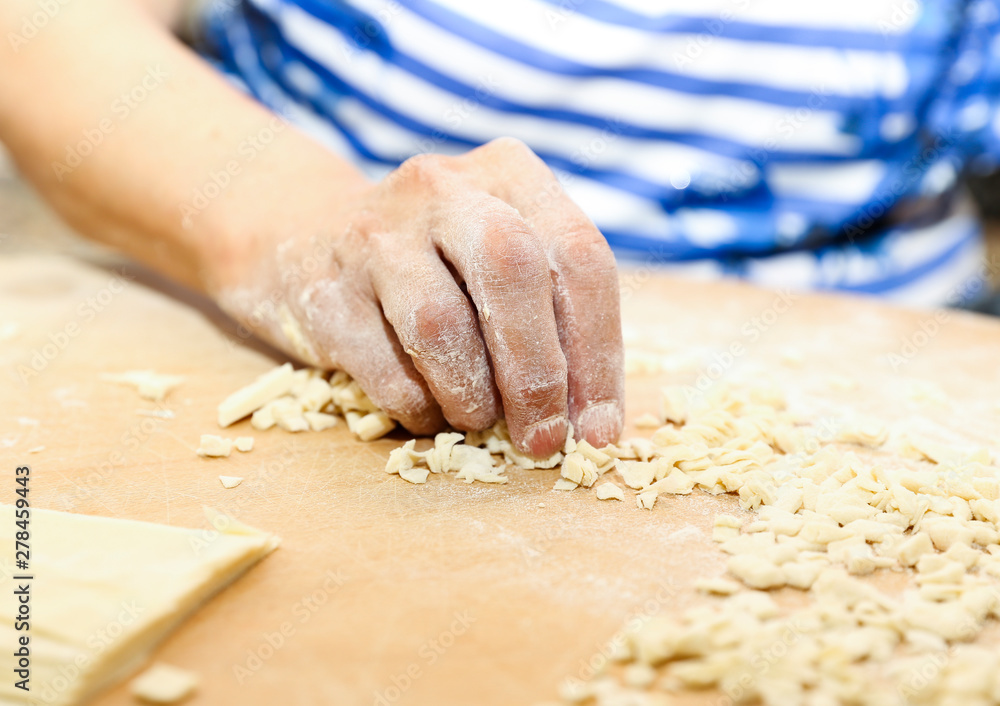 Side view woman's hands make Turkish Ravioli on table. Plates of traditional Turkish food. manti Side view woman's hands make Turkish Ravioli on table. Plates of traditional Turkish food. manti