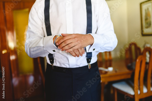 Man putting on a white shirt to dress elegantly. © Joaquin Corbalan