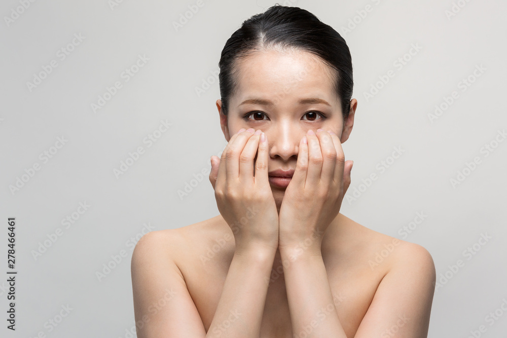 まぶたをおさえる女性 まぶたをおさえる女性
