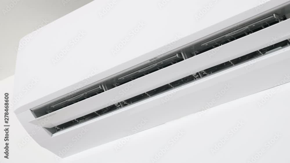 Flat air conditioner on white wall in room. Closeup Flat air conditioner on white wall in room. Closeup