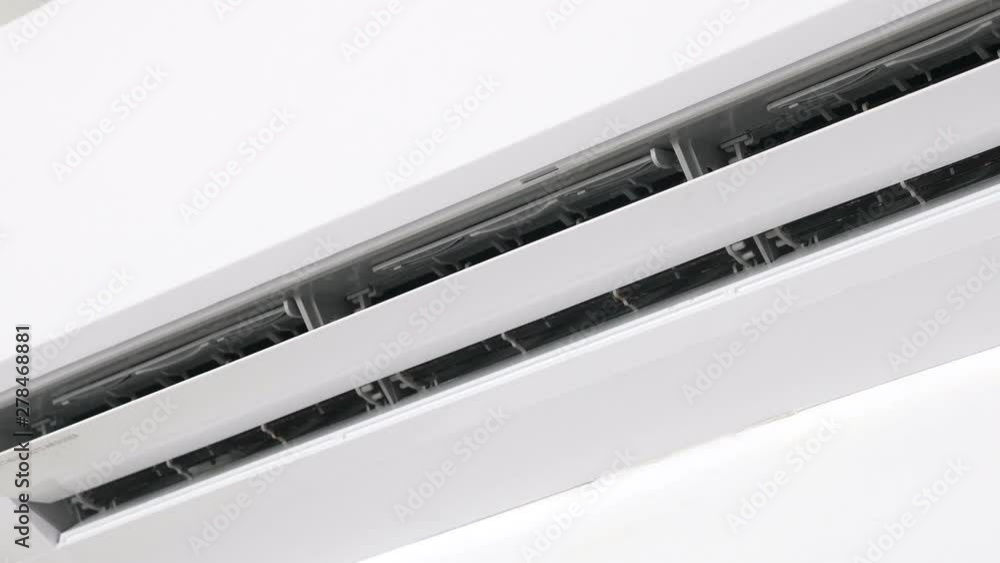 Flat air conditioner on white wall in room. Closeup Flat air conditioner on white wall in room. Closeup
