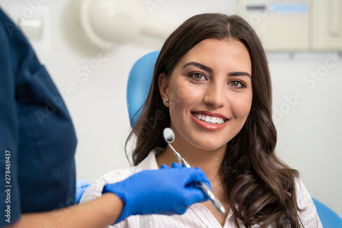 Young woman with gorgeous smile at dentist  looking at camera 