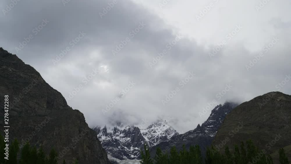 A beautiful timelapse of dense dark clouds eventually covering the mountain full of snow.