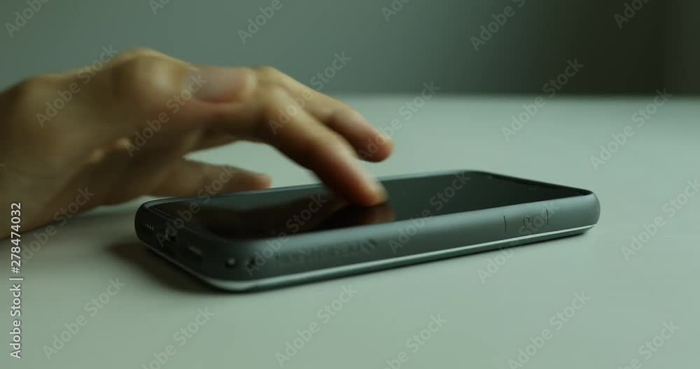 Close up shot of hand using smartphone on table Close up shot of hand using smartphone on table