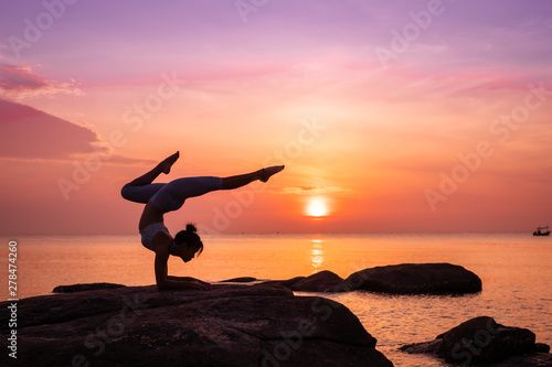 Asian girl practice Yoga on the beach Sunrise morning day