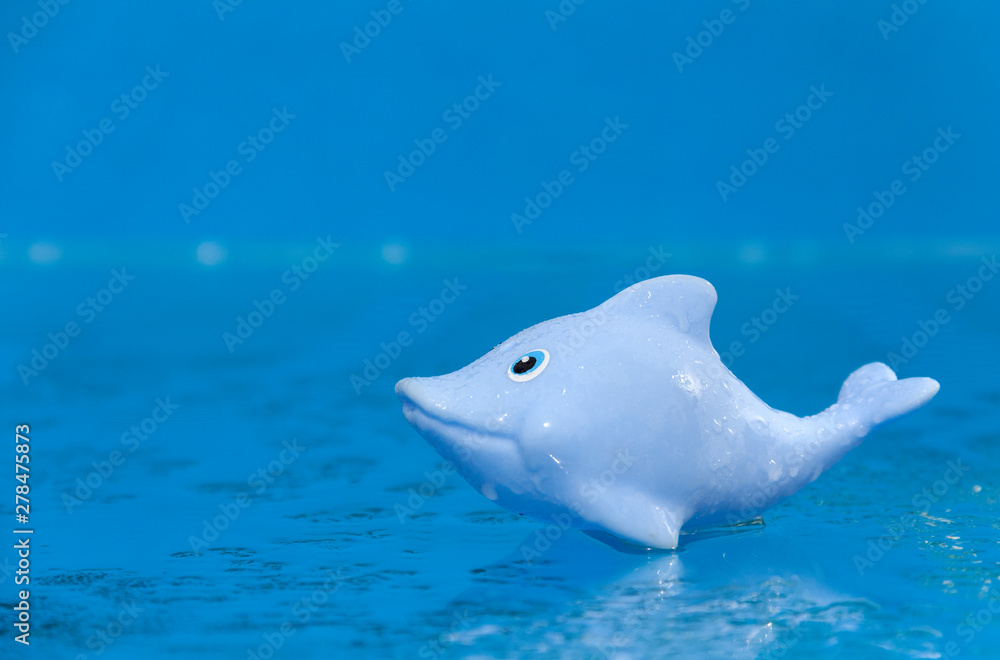 Blue toy dolphin on a sea background