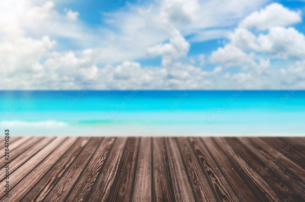 Blur tropical beach with bokeh sun light wave on empty old nature wood table abstract background. Blur tropical beach with bokeh sun light wave on empty old nature wood table abstract background.