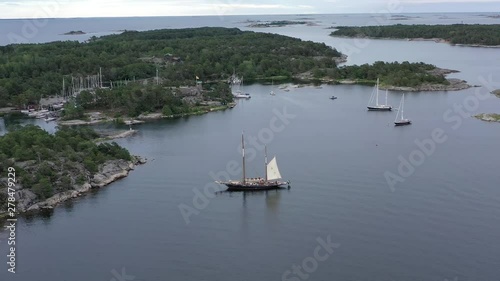 Aerial pullback from a beautiful sailing ship moored near the marina of Sandhamn, Sweden at the start of the annual round Gotland boat race. photo