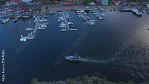 A luxury yacht arrives at Sandhamn marina, a town on the Stockholm Archipelago. Aerial drone shot photo