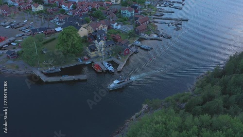 A yacht makes its way through a narrow waterway near Sandhamn marina, a town on the Stockholm Archipelago. Aerial drone shot photo