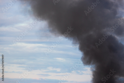Factory chimney smoking, heavy black smoke on the sky.
