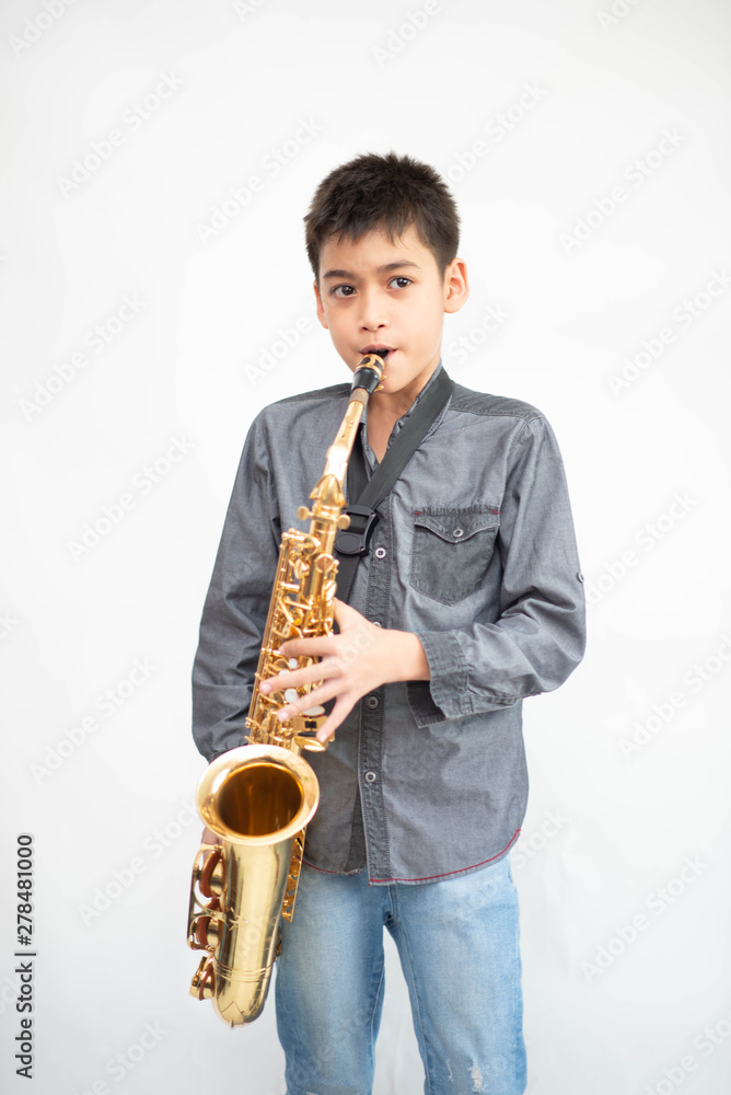 Fototapeta premium Little asian musician boy playing saxophone instrument