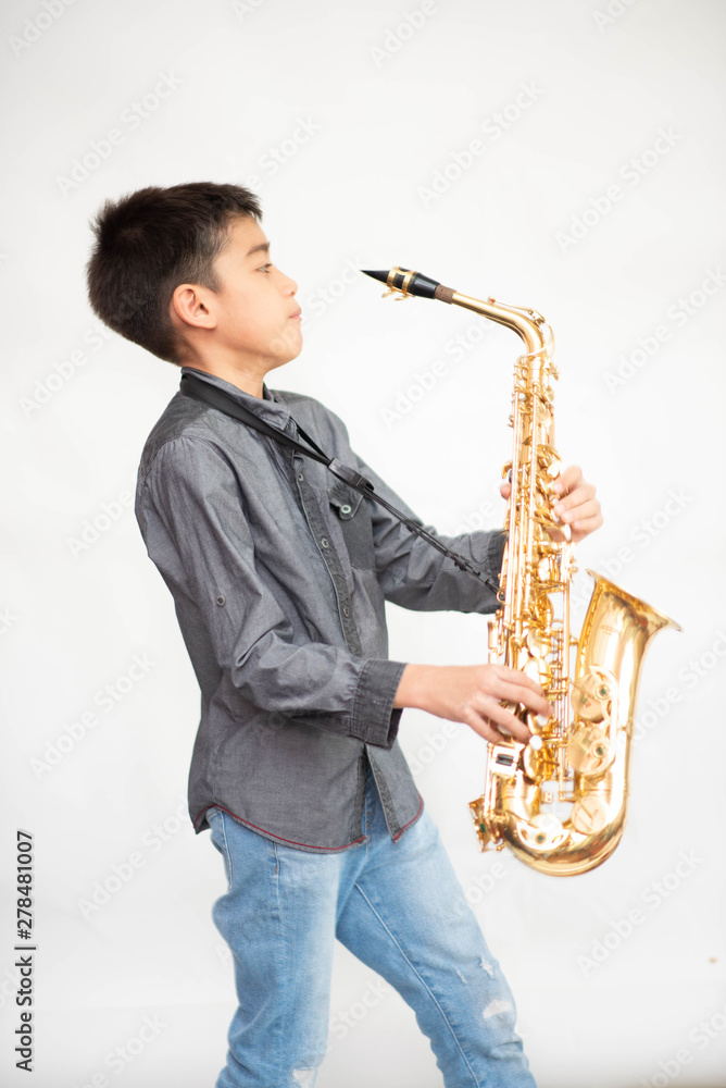 Fototapeta premium Little asian musician boy playing saxophone instrument