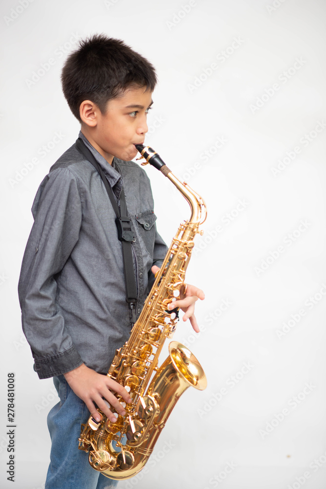 Fototapeta premium Little asian musician boy playing saxophone instrument