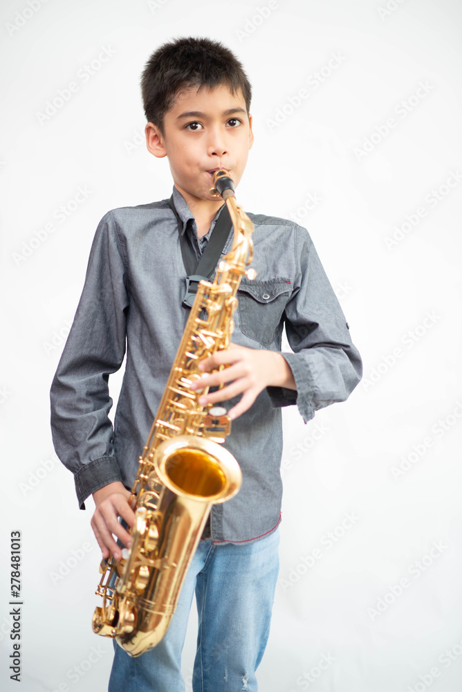 Fototapeta premium Little asian musician boy playing saxophone instrument
