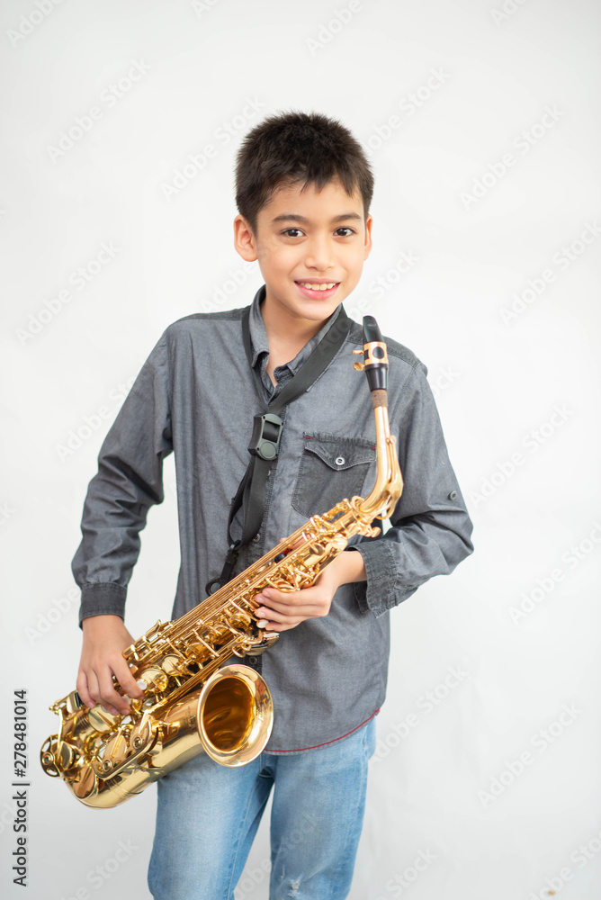 Fototapeta premium Little asian musician boy playing saxophone instrument
