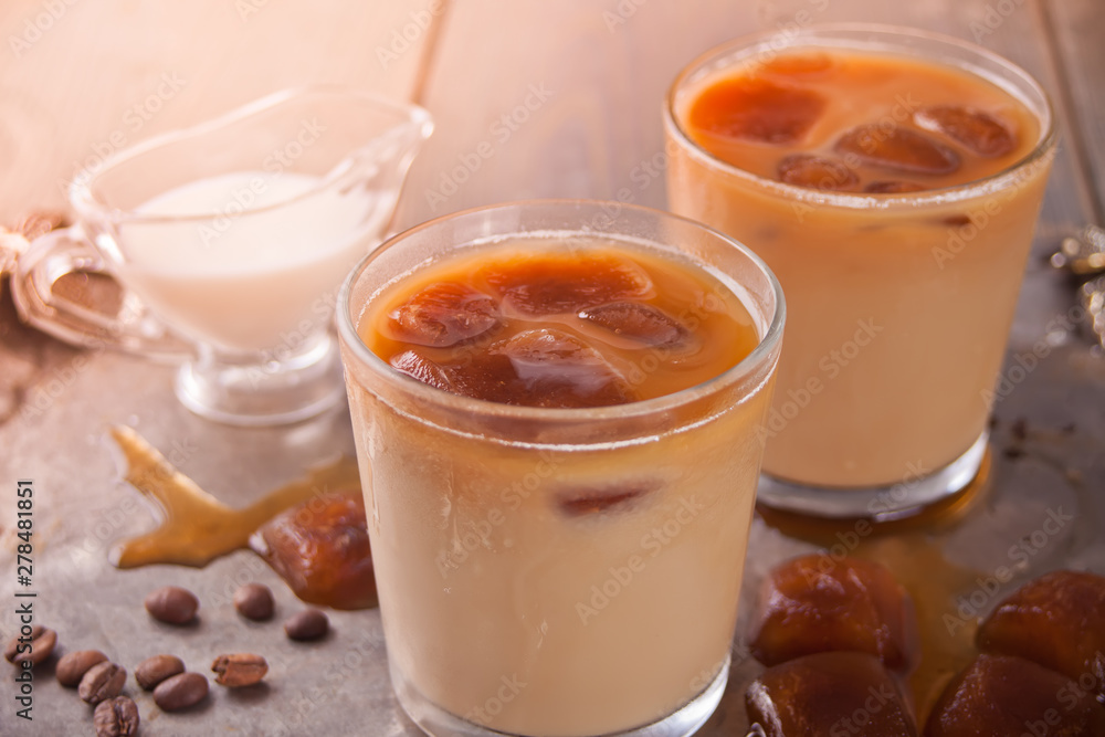 Iced latte coffee with ice cubes and coffee beans on a table. Iced latte coffee with ice cubes and coffee beans on a table.