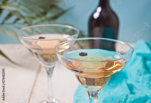 White wine in a glasses, bottle on the white wooden background. Dinner for two. photo