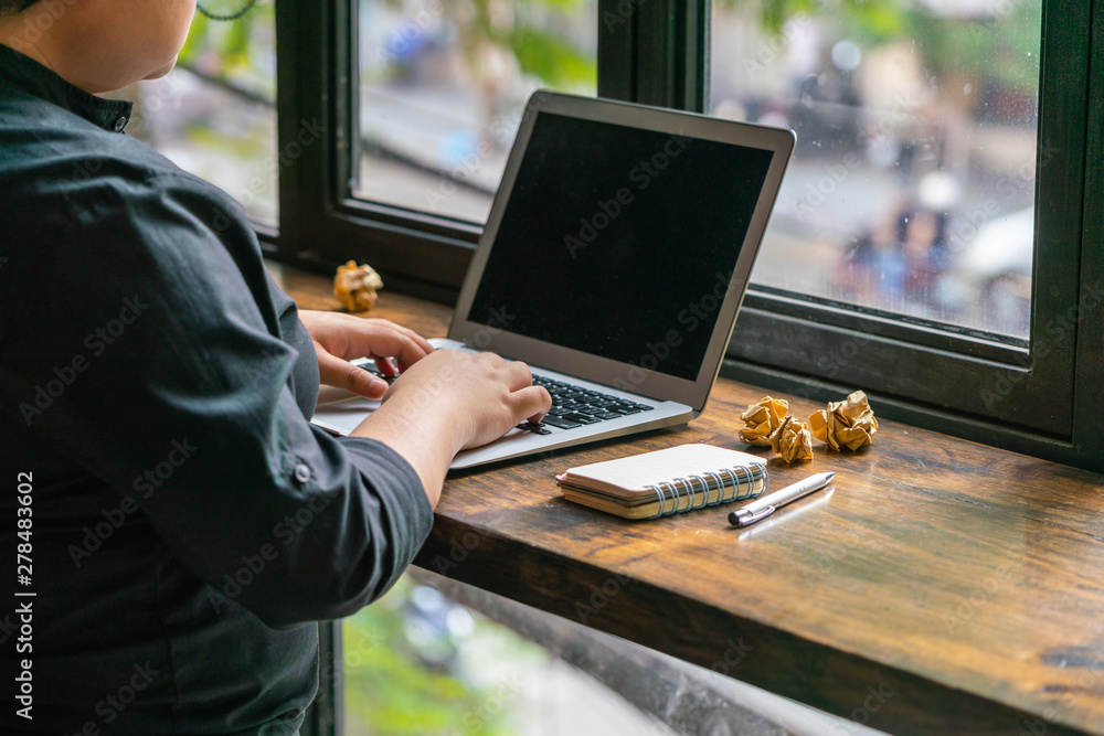 Young millennial standing and working on laptop Young millennial standing and working on laptop
