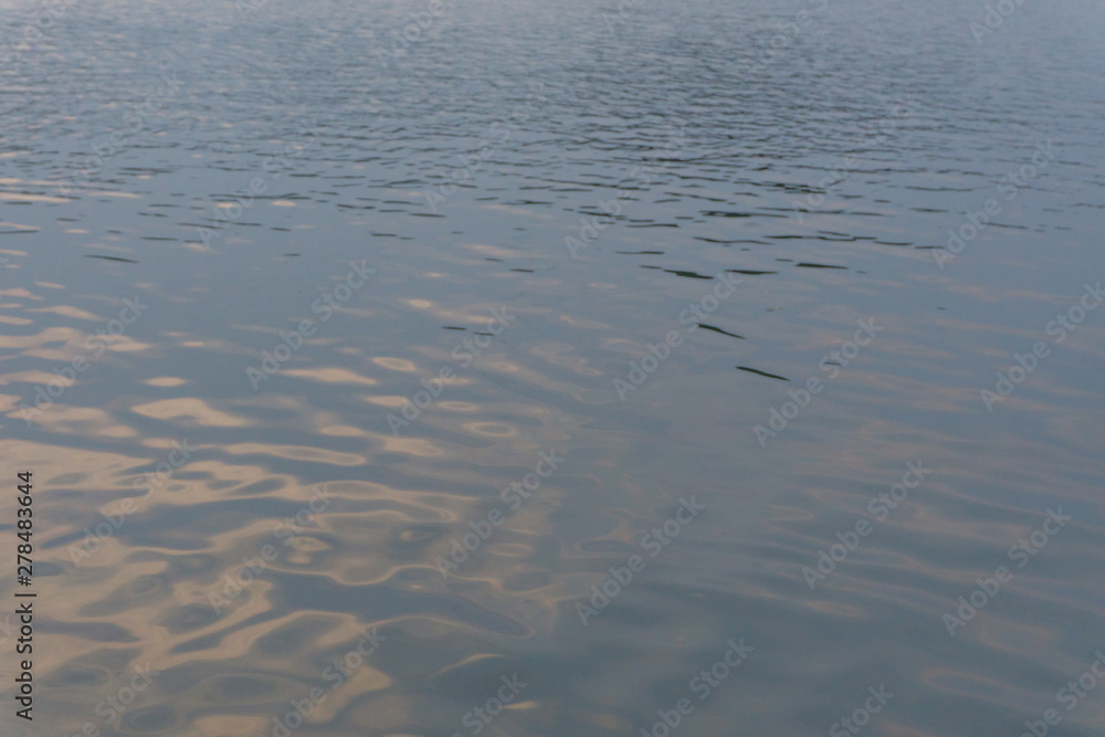 Water ripple surface reflection effect from sunset and sky top view at lake in evening day,gold wave nature abstract background Water ripple surface reflection effect from sunset and sky top view at lake in evening day,gold wave nature abstract background