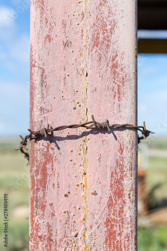 barbed wire on an iron rack against the blue sky