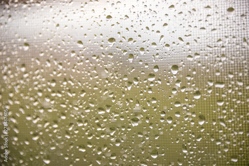 texture of rain drops on dirty window glass over blur and cloudy sunset sky background