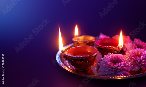 Colorful clay diya lamps lit during diwali celebration with copy space