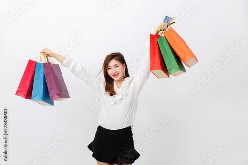 Portrait of beautiful woman holding shopping bags and credit card over white background