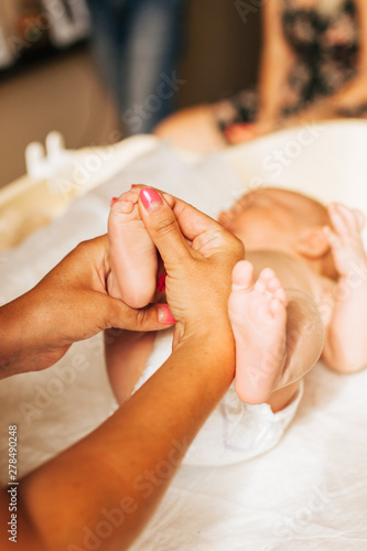 doctor massaging small baby's foot