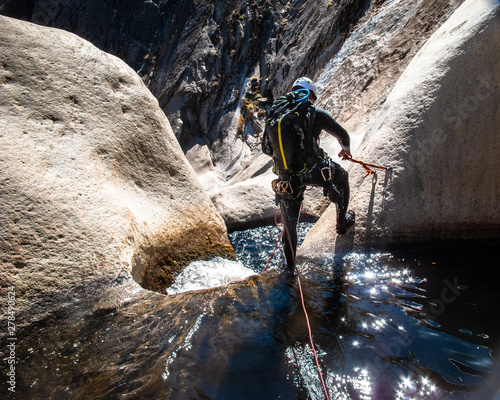 Canyoneer Sets Anchor Above Granite Waterfall