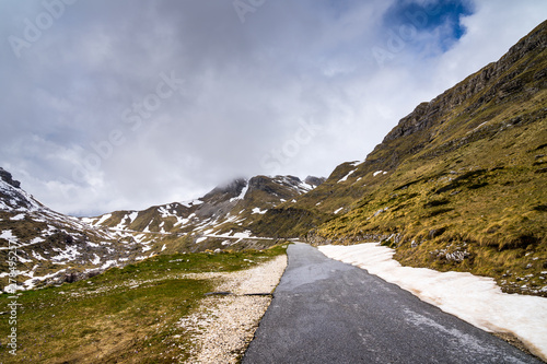 Montenegro, Sedlo pass route partly covered by snow leading through majestic durmitor national park highlands mountains near zabljak in springtime photo