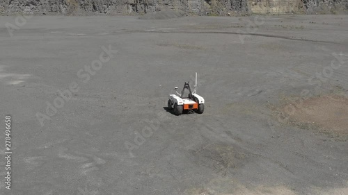 Drone, aerial footage of rover in quarry similar to mars or moon photo