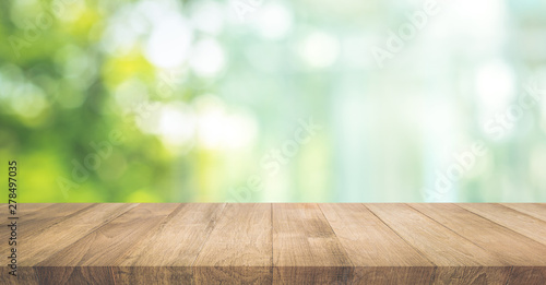 Real wood table top texture on blur leaf tree garden background. photo