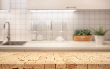Wood table top on blur kitchen counter (room)background.