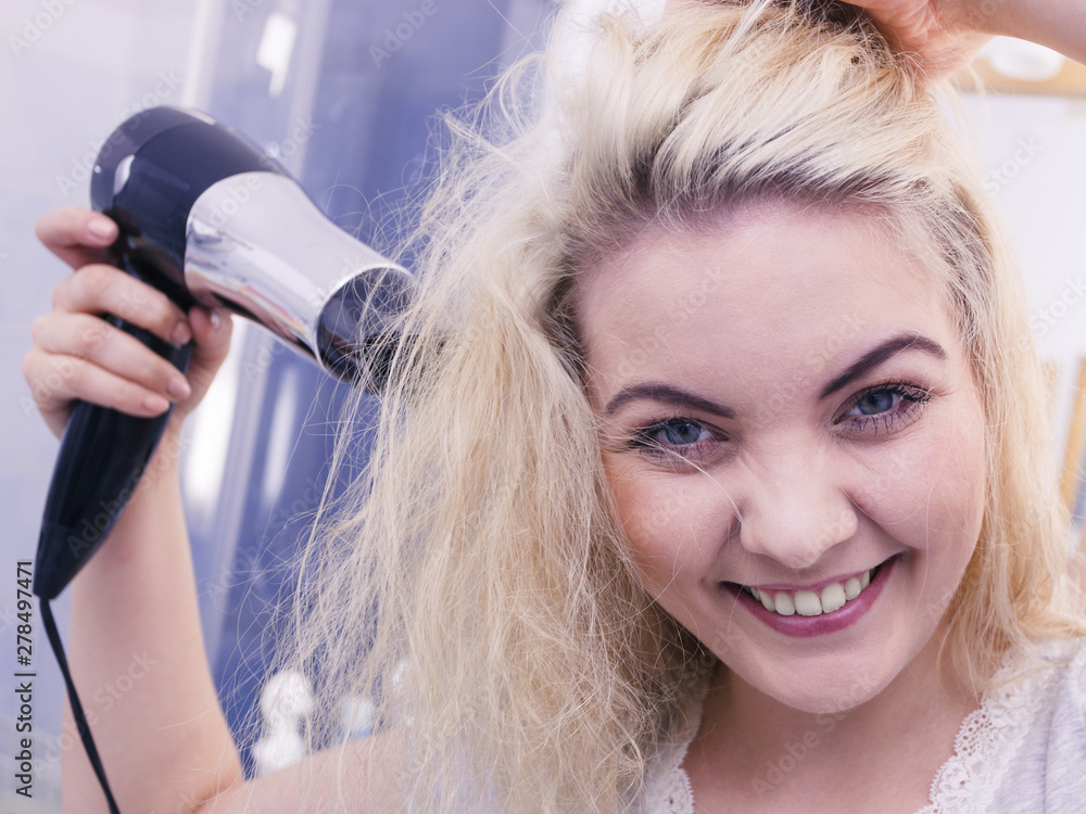 Fototapeta premium Woman drying hair in bathroom