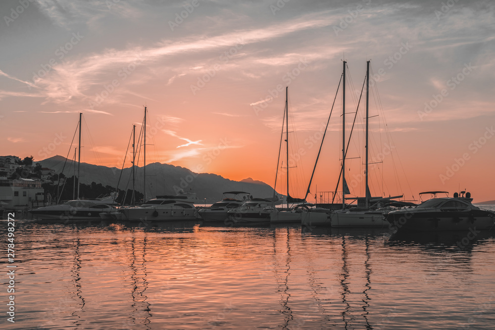 Sunset in Baska Voda town with Adriatic Sea and boats, Croatia