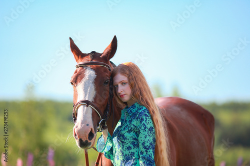 girl hugging a horse.Summer meadow