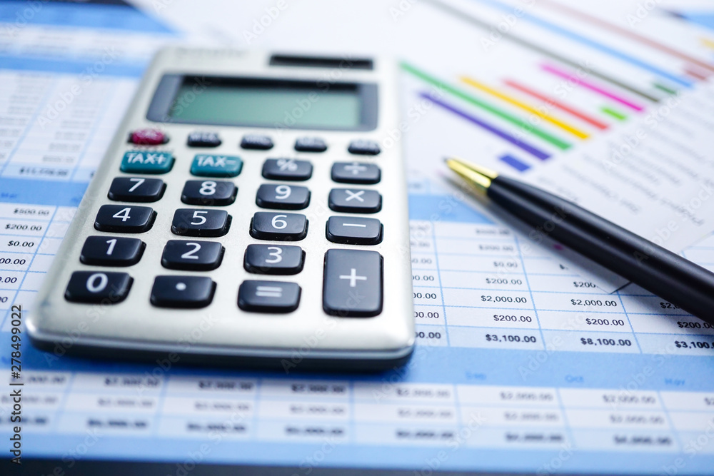 Calculator on charts and graphs spreadsheet paper. Finance, Account, Statistics, Analytic research data and Business company meeting concept Calculator on charts and graphs spreadsheet paper. Finance, Account, Statistics, Analytic research data and Business company meeting concept