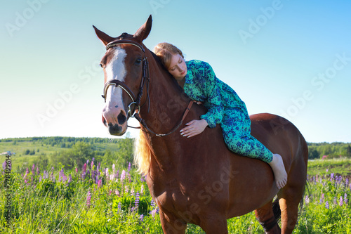 girl hugging a horse.Summer meadow