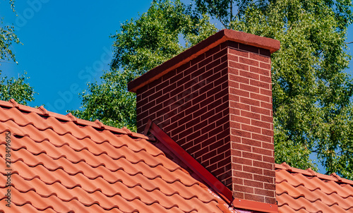 Chimney on the roof covered with red tiles