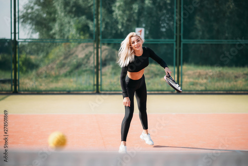 Young beautiful woman playing tennis on a court. Healthy sport lifestyle