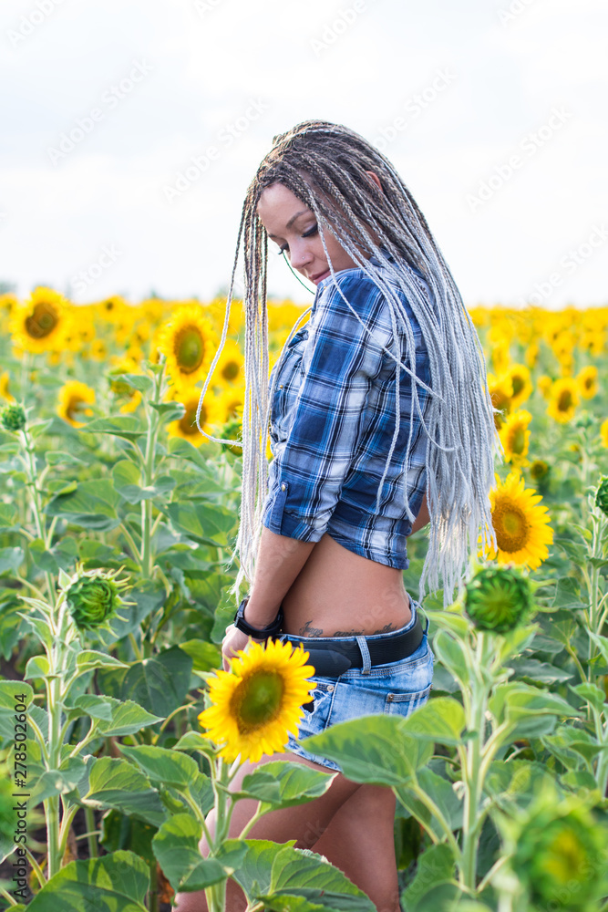 young cute tannet country girl with afro-braids on the sunflowers field young cute tannet country girl with afro-braids on the sunflowers field