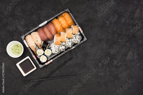 Sashimi sushi set with soy and wasabi on black background