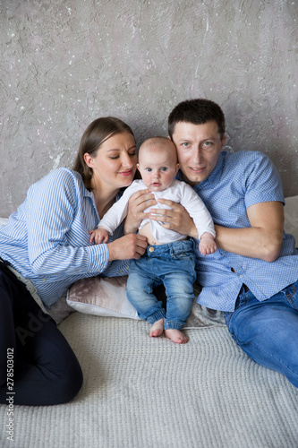 Happy Young Caucasian Family Lying on Bed